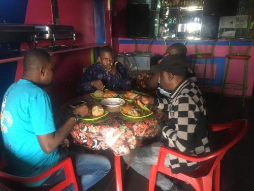 基加利PagersHome Suites - Classic Nyarutarama的一群坐在餐桌上吃食物的人