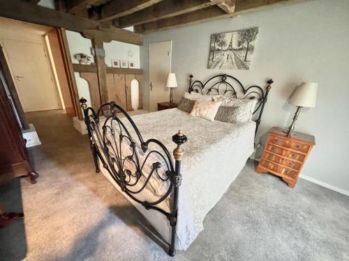 TrocheDordogne et Corrèze vacances BnB的一间卧室配有一张大床和一个木制梳妆台