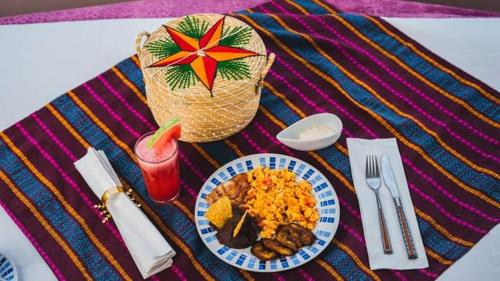 巴里奥斯港Hotel Posada Stella Maris的一张桌子,上面有盘子的食物和一篮子的稻草