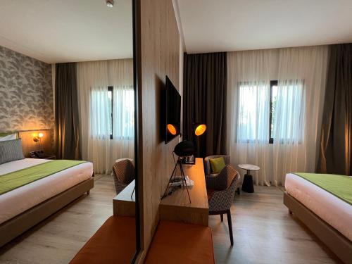 丹吉尔Hotel Ben Batouta - Tanger的酒店客房,设有两张床和镜子
