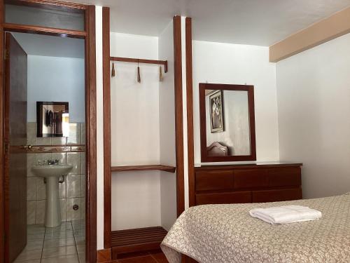 CarhuazLas Torrecitas的一间卧室配有一张床、一个水槽和淋浴
