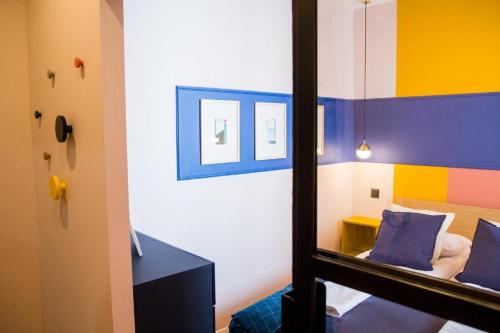 托伦HOLI的一间设有镜子的客房和一张色彩缤纷的墙壁床