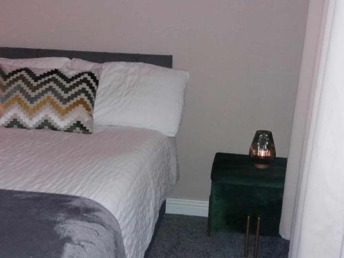 卡里格莱恩Dún Eoin Carrigaline的一间卧室配有一张床和一张带台灯的桌子