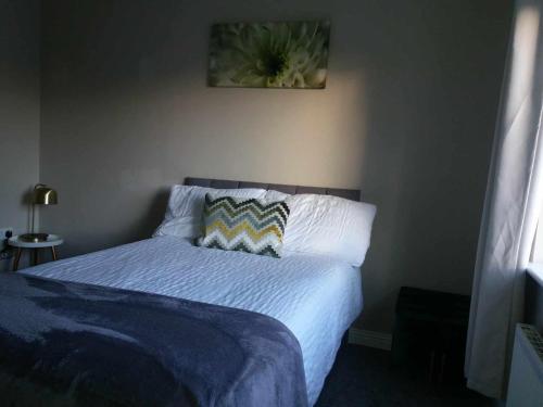 卡里格莱恩Dún Eoin Carrigaline的卧室内的一张带蓝色棉被和枕头的床