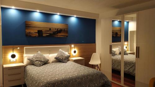 贝梅奥Apartamento con encanto "ZIRIMIRI"的一间卧室设有两张床和蓝色的墙壁
