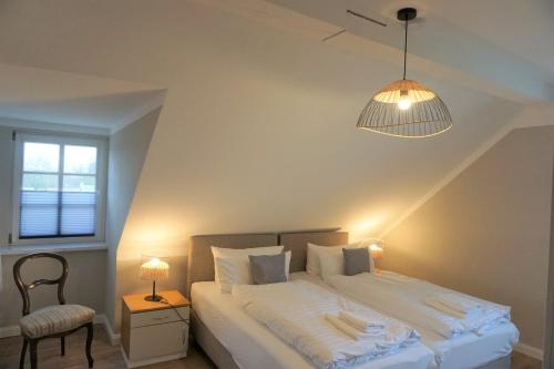 ReestowLerchenhof - Haus Wiesengrund的一间卧室配有一张带灯和椅子的床