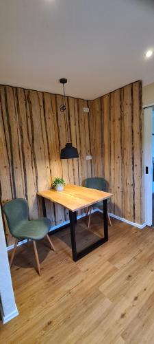 宁布雷希特Jedermanns Nest的一间带木桌和两把椅子的用餐室