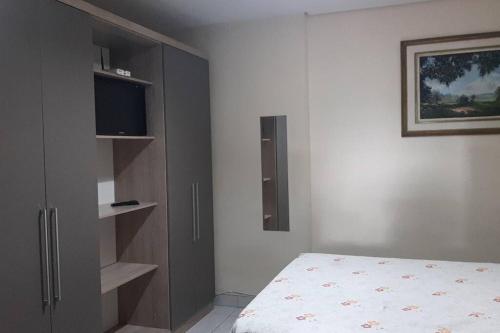 贝洛奥里藏特Kitinet Central的一间卧室配有一张床和一台平面电视
