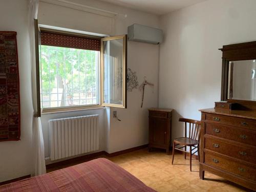 莱切Villa Margherita的一间卧室设有窗户、椅子和梳妆台
