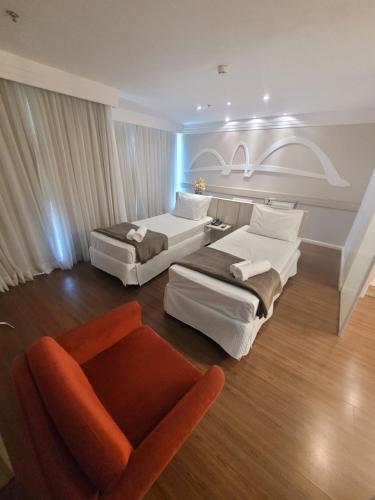 巴西利亚Flat Brasília Lider By Rei dos Flats的酒店客房,配有两张床和椅子