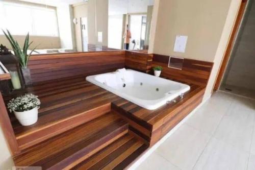 戈亚尼亚Flat Luxo Jardim Goiás的带浴缸的浴室,铺有木地板