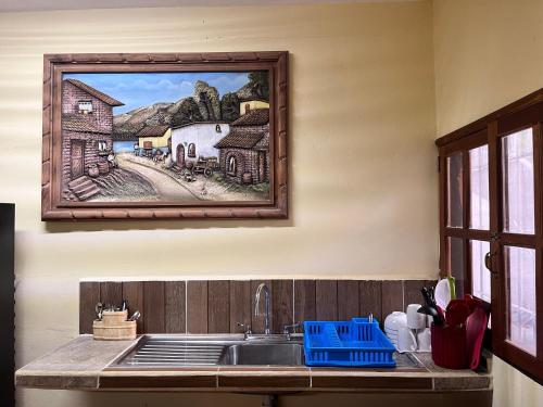 图卢姆Tumben Kuxtal Tulum的厨房配有水槽,墙上挂有绘画作品