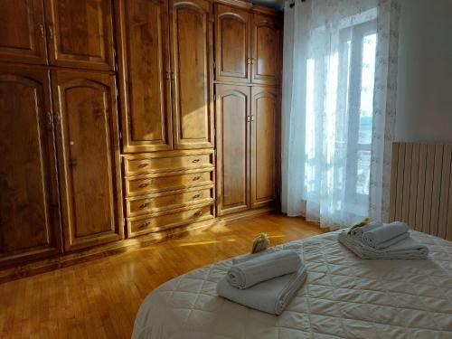 博尔塞纳Casa Rosita vista lago的一间卧室配有木制橱柜和一张带毛巾的床。