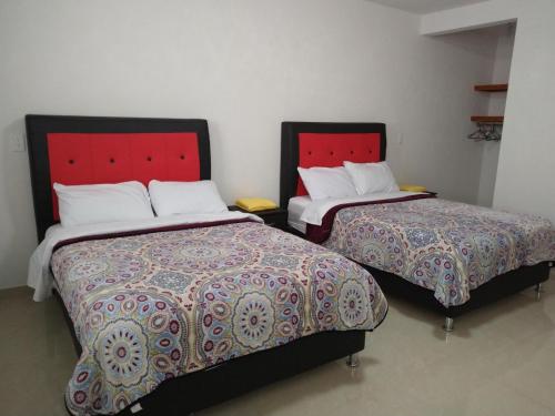 圣胡安特奥蒂瓦坎Hotel Fer的两张睡床彼此相邻,位于一个房间里