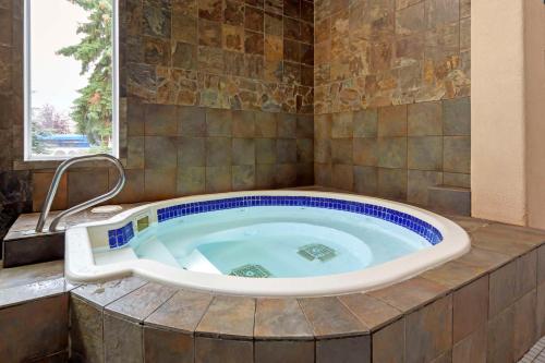 埃德蒙顿市中心贝斯特韦斯特优质酒店的带窗户的浴室内的按摩浴缸