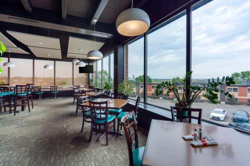 埃德蒙顿市中心贝斯特韦斯特优质酒店的餐厅设有桌椅和大窗户。