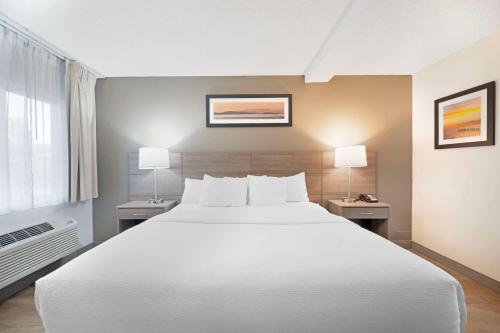 爱达荷福尔斯Quality Inn Idaho Falls的卧室配有一张白色大床和两盏灯。