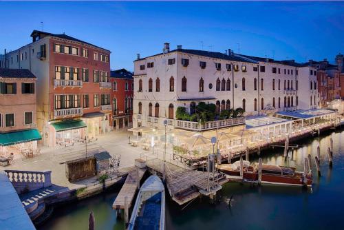 威尼斯NH Venezia Santa Lucia的运河旁的一组建筑物