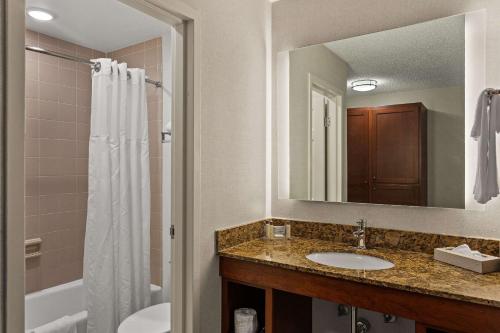 南本德The Clover Hotel, Ascend Hotel Collection的一间带水槽、淋浴和镜子的浴室