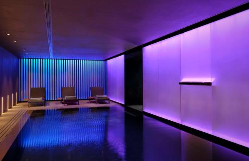 萨格勒布art'otel Zagreb, Powered by Radisson Hotels的一间设有紫色灯光游泳池的客房