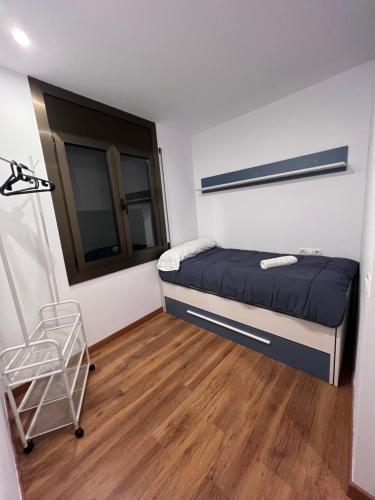 安道尔城Piso Andorra的一间铺有木地板的小卧室,配有一张床