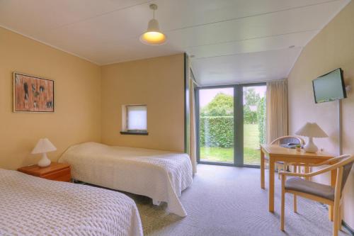 尼斯泰兹小屋乡村别墅的酒店客房设有两张床和窗户。