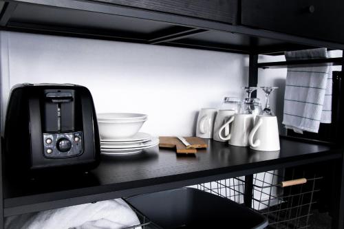 达格维尔Rustic Rails Accommodation的黑色柜台,上面有烤面包机和盘子