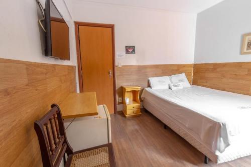 戈亚尼亚Hotel Terra Cedro In的小房间设有床和电视