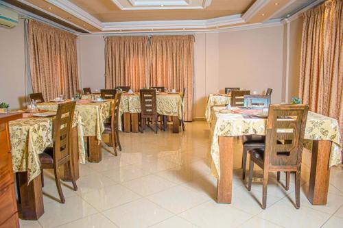布拉柴维尔Hotel Murex的用餐室配有桌椅和窗帘