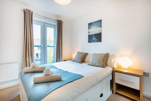 曼彻斯特Manchester Serviced Accomodation NorthernNightzzz - The Gardens的一间卧室配有一张大床和两条毛巾