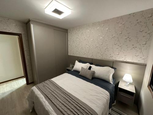 卡庞达卡诺阿Apto super luxo beira mar Capão da Canoa的一间卧室设有一张床和鲜花墙