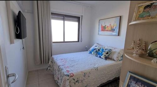 卡庞达卡诺阿Apartamento Beira mar Capão da Canoa的一间小卧室,配有床和窗户