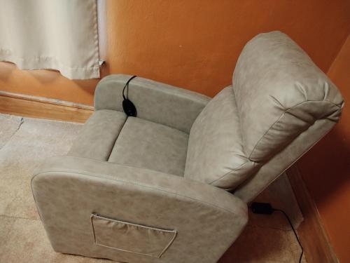 盖尔斯堡Cool and affordable apartment Galesburg的一张灰色的椅子,坐在墙上的房间里
