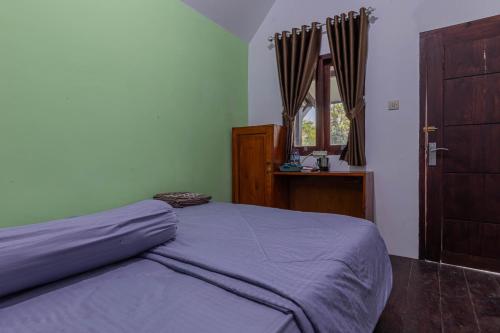 塞姆博伦拉旺Bale Gantar的一间卧室设有床、窗户和门