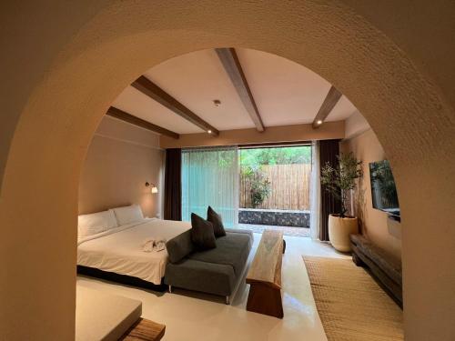 拉差汶里茵拉亚拉查布里旅馆的卧室配有床、椅子和窗户。