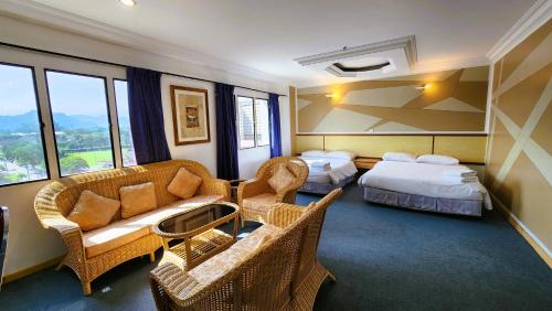怡保Fair Park Premier的酒店客房带两张床、一张沙发和椅子。