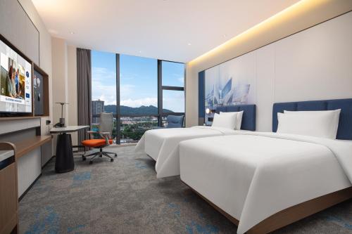 增城广州新塘希尔顿欢朋酒店的酒店客房设有两张床和电视。