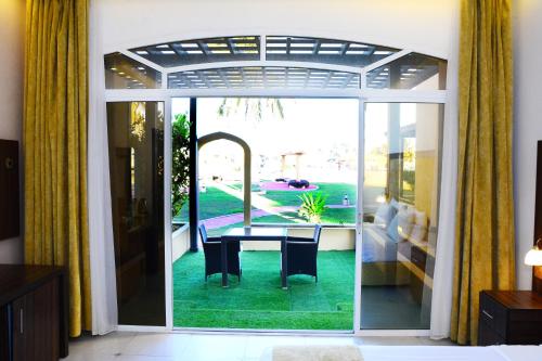 塞拉莱Samharam Resort Salalah的配有桌子并享有庭院景色的客房