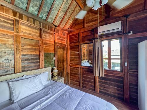 艾湄湾Room 3, Agung Guesthouse at Melasti Mountain Villas, Amed的小木屋内一间卧室,配有一张床
