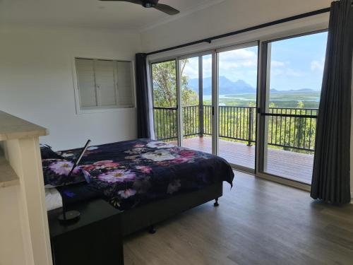 卡德韦尔Vista Hinchinbrook的一间卧室设有一张床和一个大型滑动玻璃门