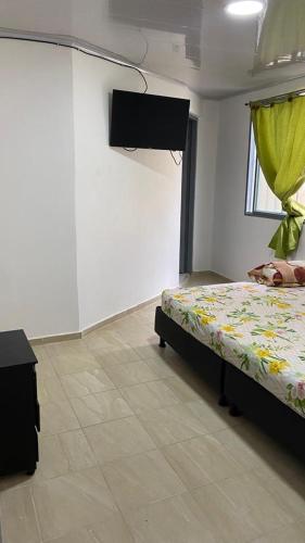 圣罗莎德卡瓦尔Restaurante y hospedaje La fonda的一间卧室配有一张床和一台电视。