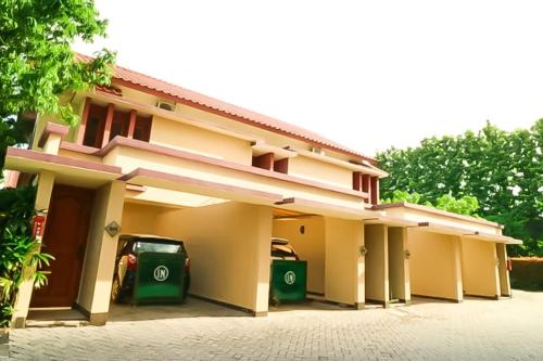 雅加达Hotel 678 Cawang powered by Cocotel的两根绿色垃圾箱的房子