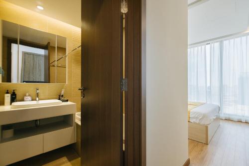 河内Royal Serviced apartment Vinhomes Metropolis的一间带水槽和镜子的浴室以及一张床