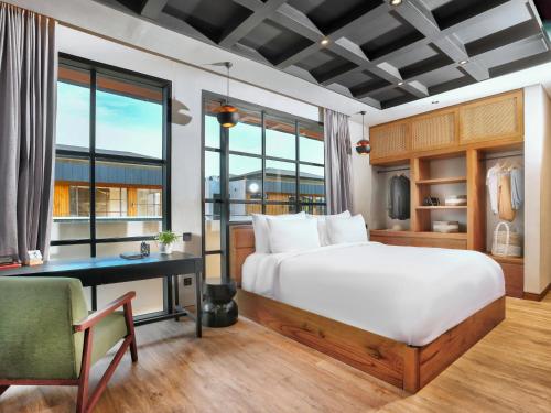 坎古Secana Beachtown的一间卧室配有一张床、一张书桌和窗户。