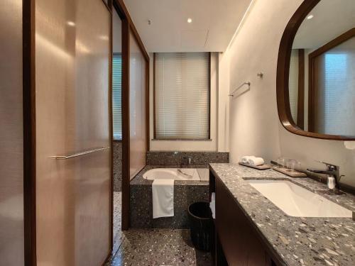 苏州苏州畅园有熊酒店的浴室设有2个水槽、浴缸和镜子