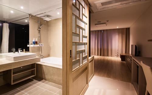 西归浦市Noblepia Hotel的浴室配有盥洗盆和浴缸。