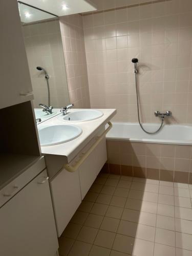 克诺克－海斯特appartement Lichttorenplein met garage的浴室配有2个盥洗盆、浴缸和淋浴。