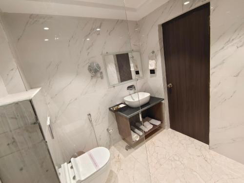 穆扎夫法尔普尔The Emerald Hotel & Siya Milan Banquets的白色的浴室设有水槽和卫生间。