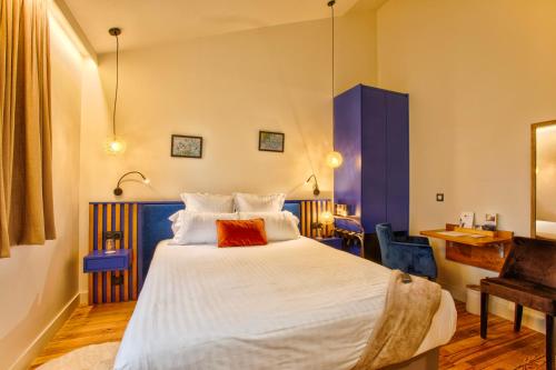 卡布尔Le Castel Cabourg hôtel & SPA- Restaurant La Calypso的卧室配有一张白色大床和一张书桌
