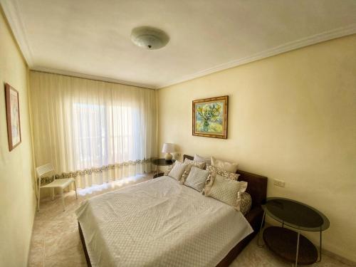阿罗纳Hugo's holiday apartment in Costa del Silencio的一间卧室配有一张床、一张桌子和一个窗户。